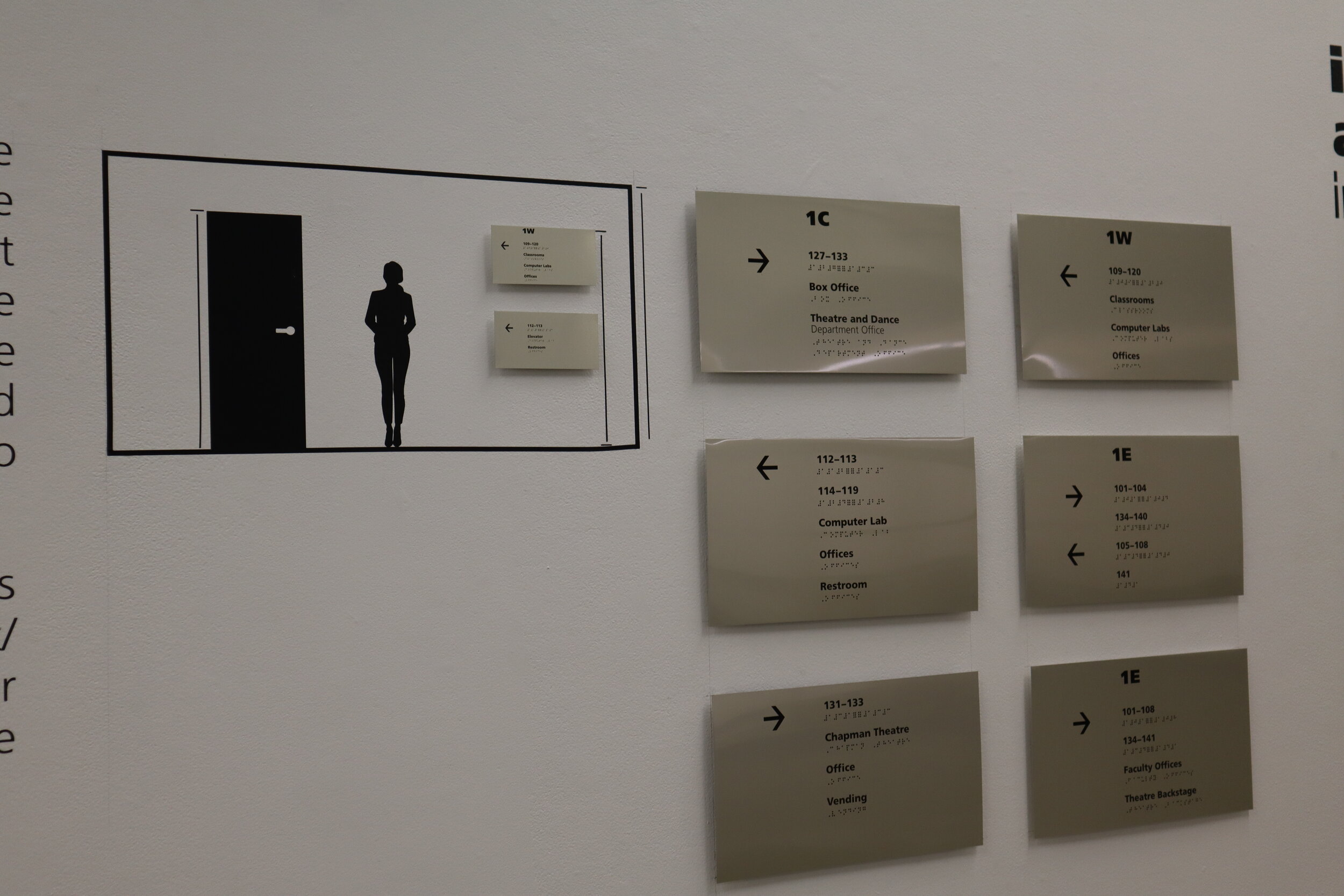 Kehinde Osho standing in front of typographic mural